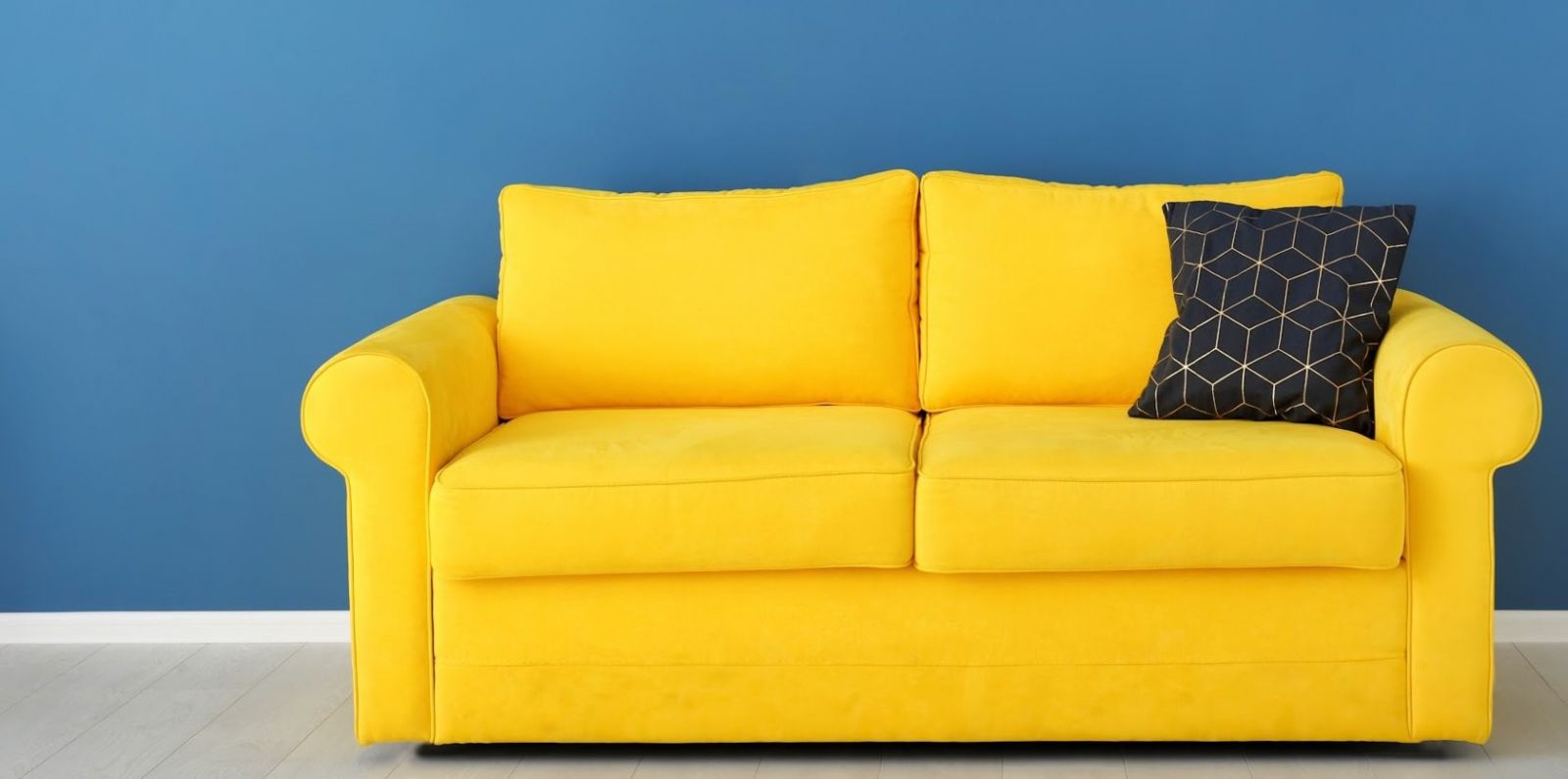 желтый диван на синей стене