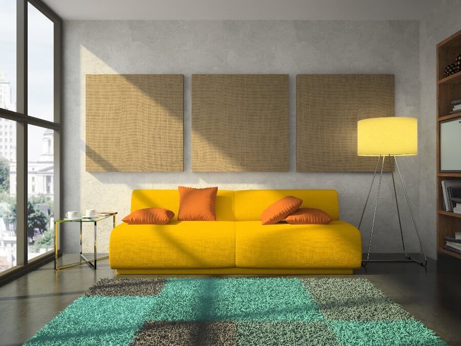желтый диван с оранжевыми подушками